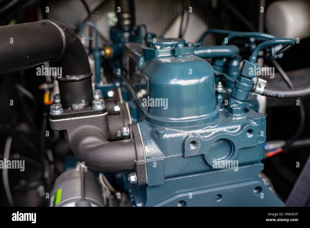 Testa del cilindro di un motore diesel industriale con coprivalvole e linee di iniezione del carburante che illustra l'ingegneria delle macchine pesanti e la trasmissione di potenza Foto Stock