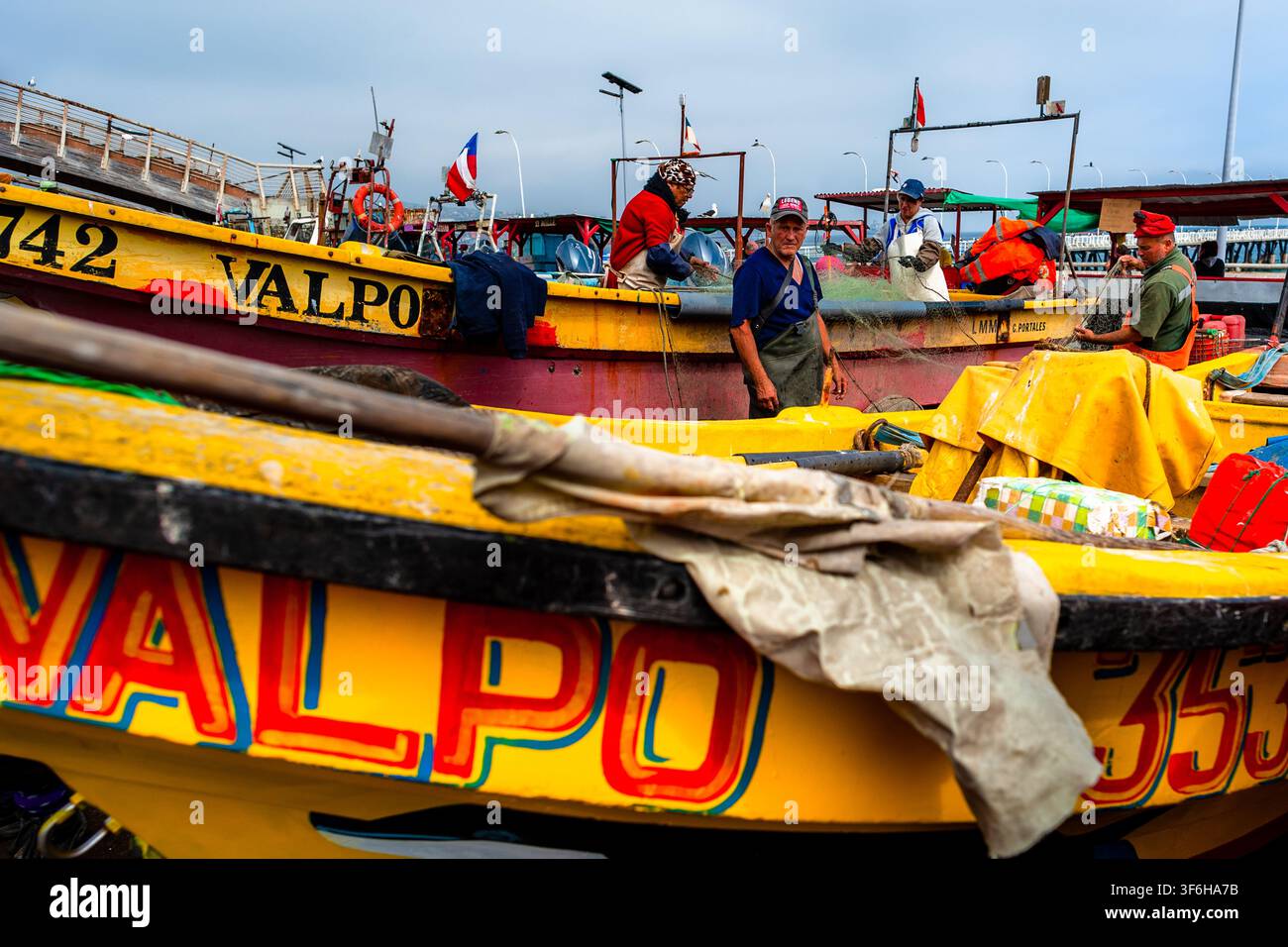 I pescatori cileni rimuovono i pesci da una rete da pesca a Caleta Portales, un porto di pesca artigianale a Valparaíso, Cile. Foto Stock