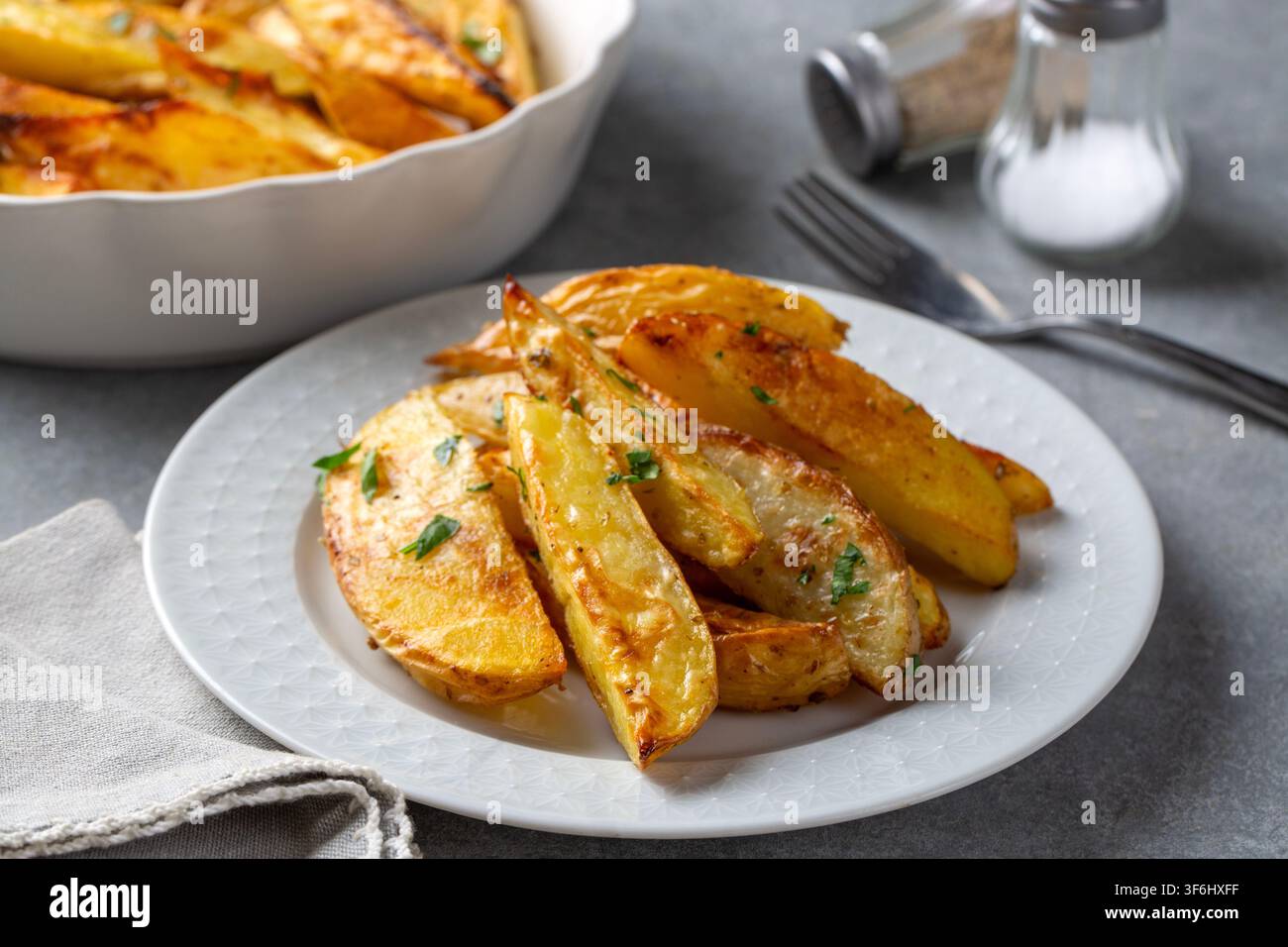 Fette di patate al forno con erbe Foto Stock