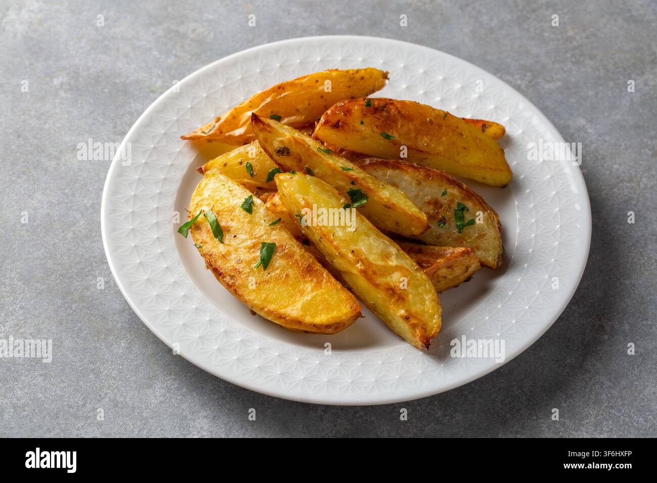 Fette di patate al forno con erbe Foto Stock