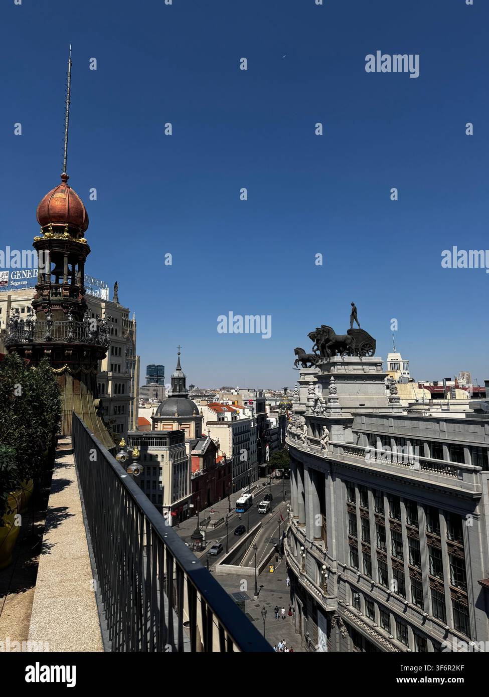 MADRID, SPAGNA - 15 LUGLIO 2025: Vista elevata di Calle de Alcala con architettura storica, l'iconica statua del quadriga sul tetto, traffico stradale - Immagine stock catturata con smartphone