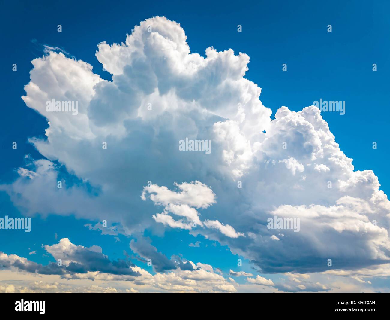 Nuvole cumulo imponenti che si ergono contro un cielo blu vivace in una luminosa giornata estiva Foto Stock
