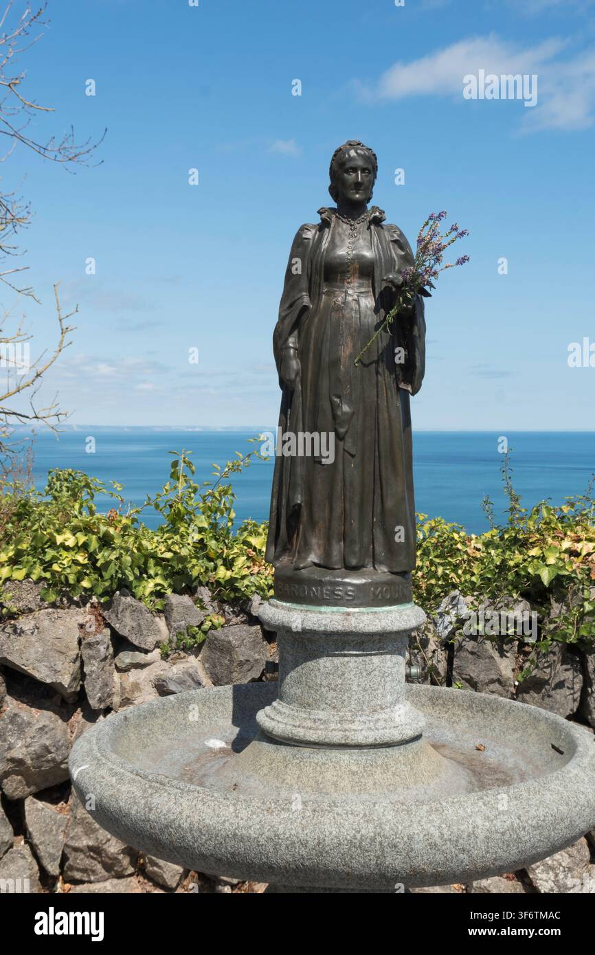 Una statua di bronzo della baronessa Mount-Temple con fiori a Babbacombe, Devon, Inghilterra, Regno Unito Foto Stock