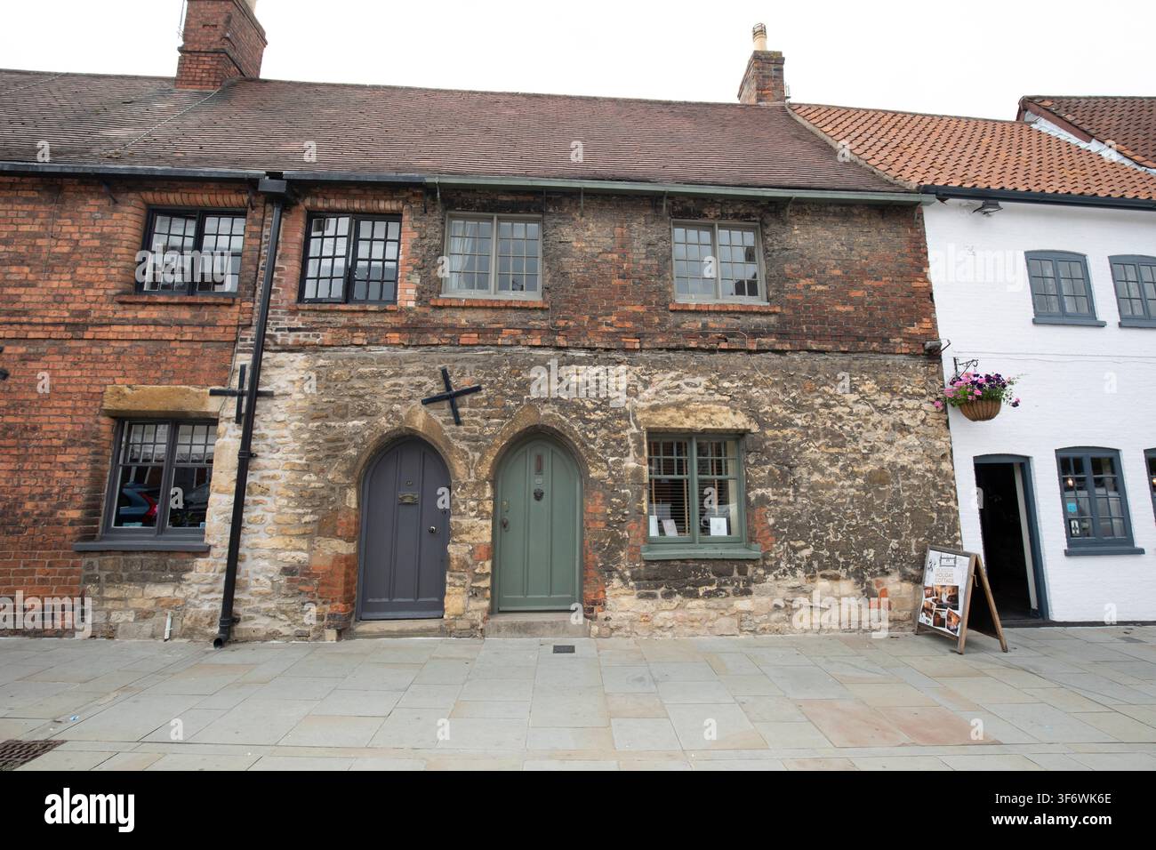 Case storiche in pietra e mattoni con porte ad arco appuntito e telai di finestre in legno a Castle Square nella vecchia città di Lincoln, Regno Unito. Foto Stock