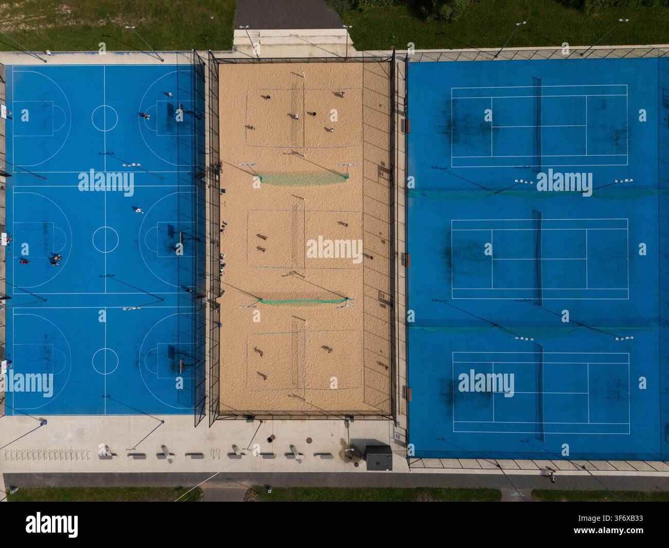 Vista aerea dall'alto di un complesso sportivo all'aperto con campi da basket, beach volley e tennis, struttura multisport urbana e concetto di svago. Foto Stock