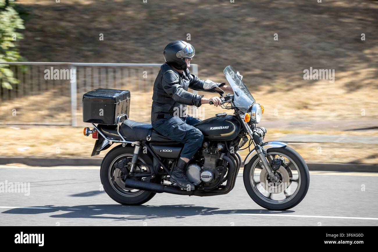 Milton Keynes, Regno Unito - 2 agosto 2026: Uomo in sella a una moto Kawasaki kz1000 degli anni '70 che guida su una strada britannica Foto Stock