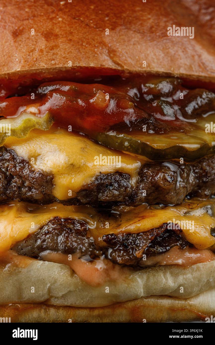 Estremo primo piano di un succoso doppio cheeseburger Foto Stock
