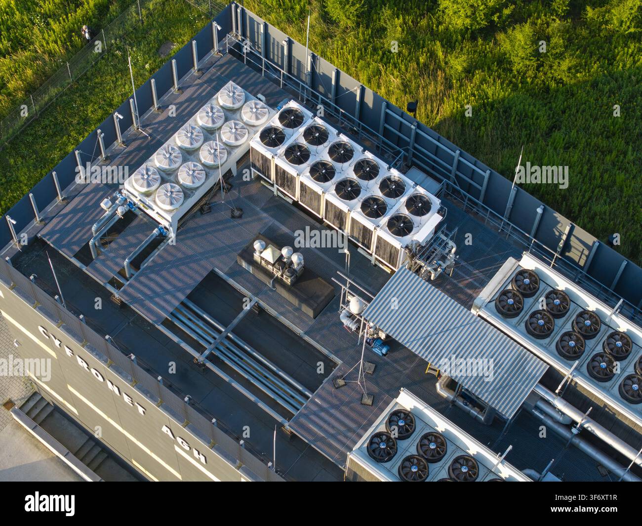 Vista aerea del tetto del centro dati Cyfronet AGH con file di ventole di raffreddamento industriali e infrastruttura metallica a Cracovia, Voivodato della Piccola Polonia Foto Stock