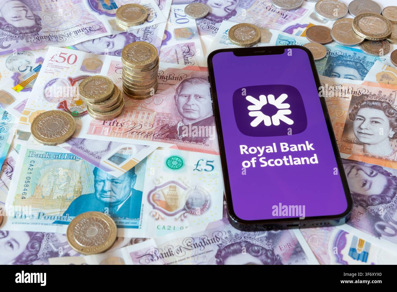 App di banking Bank of Scotland con banconote e monete in sterline sullo sfondo Foto Stock