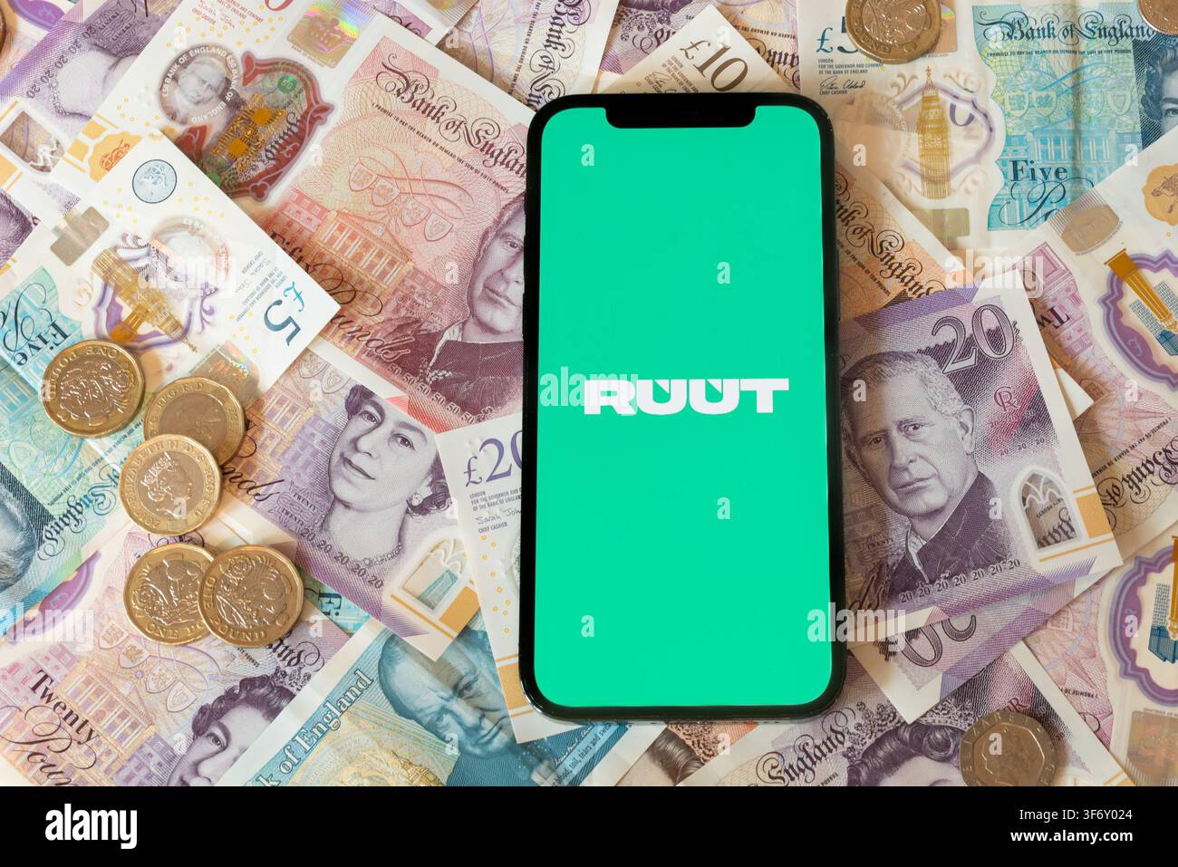 Applicazione bancaria Ruut con banconote e monete in sterline in sottofondo Foto Stock