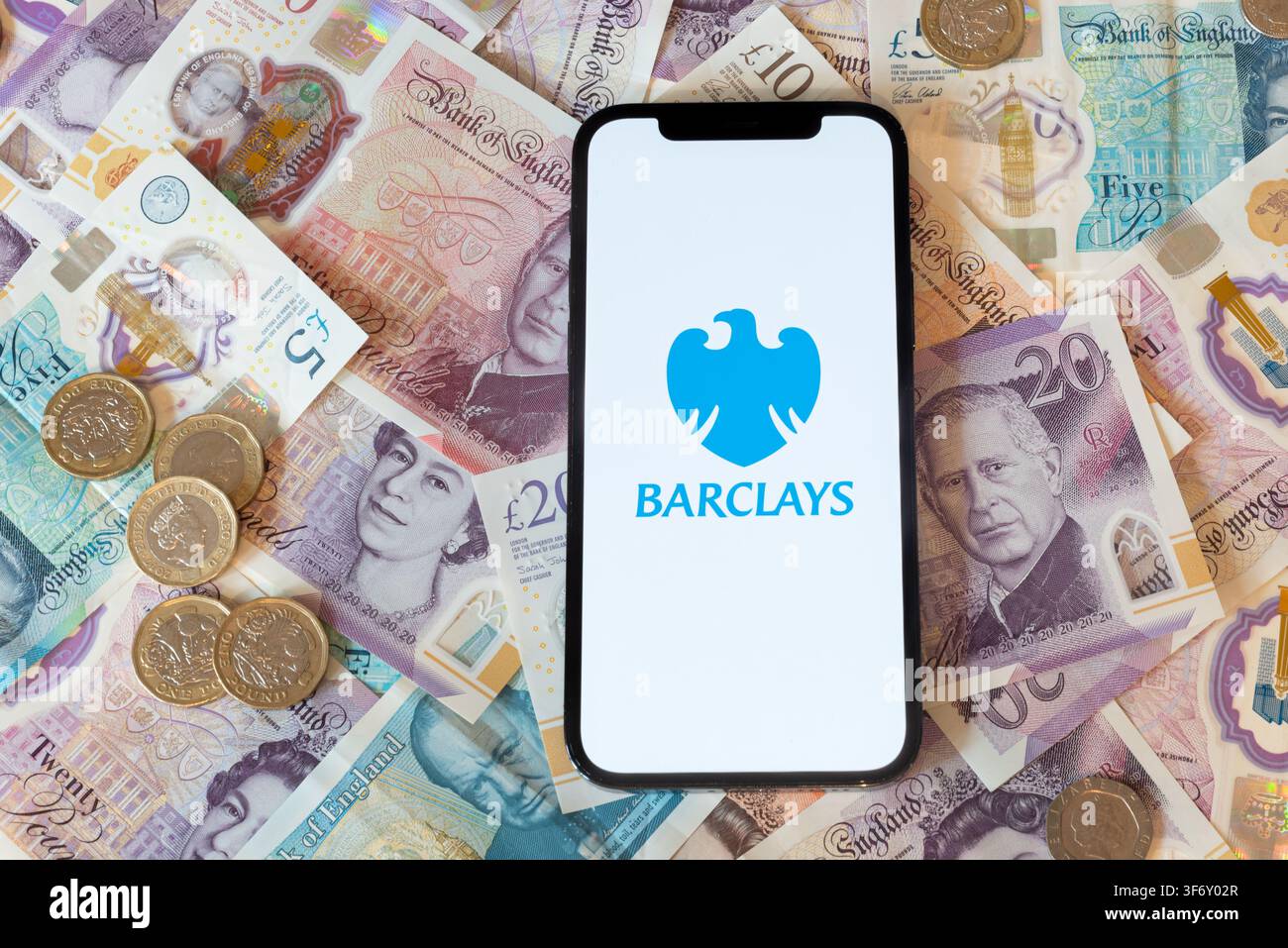 App di banking Barclays con banconote e monete in sterline sullo sfondo Foto Stock