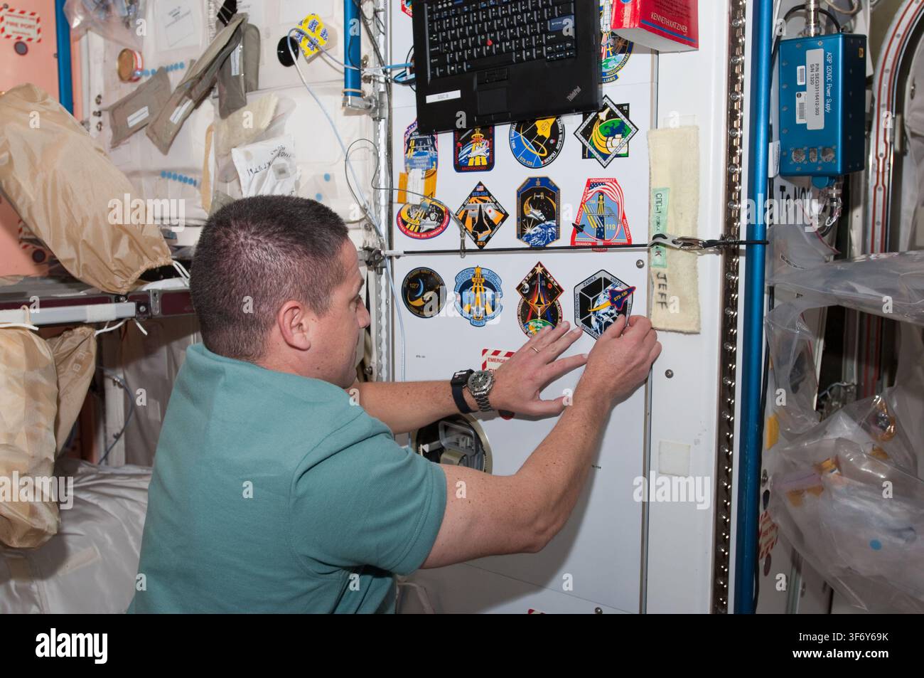 George Zamka, astronauta della NASA, che posa il patch della missione STS-130 nel Nodo 1 della Stazione Spaziale Internazionale durante la missione STS-130. Foto Stock