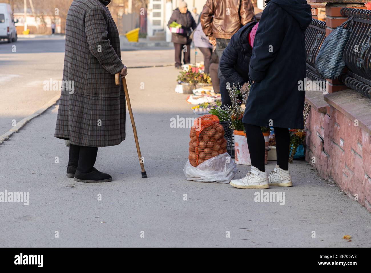 Acquisti di verdure fresche da un'esposizione informale di mercato sul marciapiede in un'area urbana, che riflette le routine quotidiane tipiche, l'accesso locale al cibo e Foto Stock