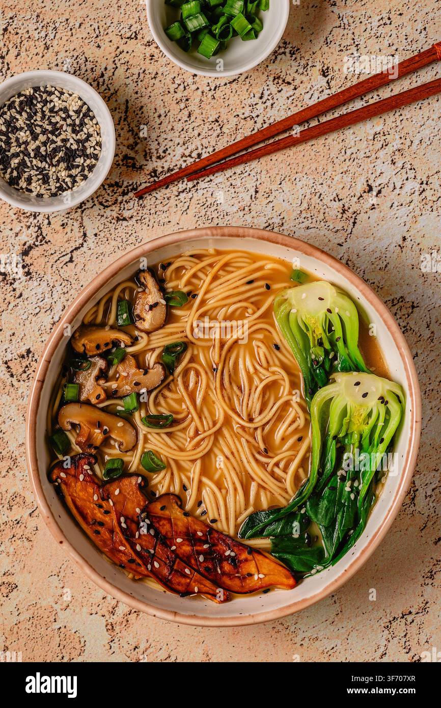 Zuppa di noodles ramen miso vegana con funghi eryngii e shiitake, cavolo pak choi Foto Stock