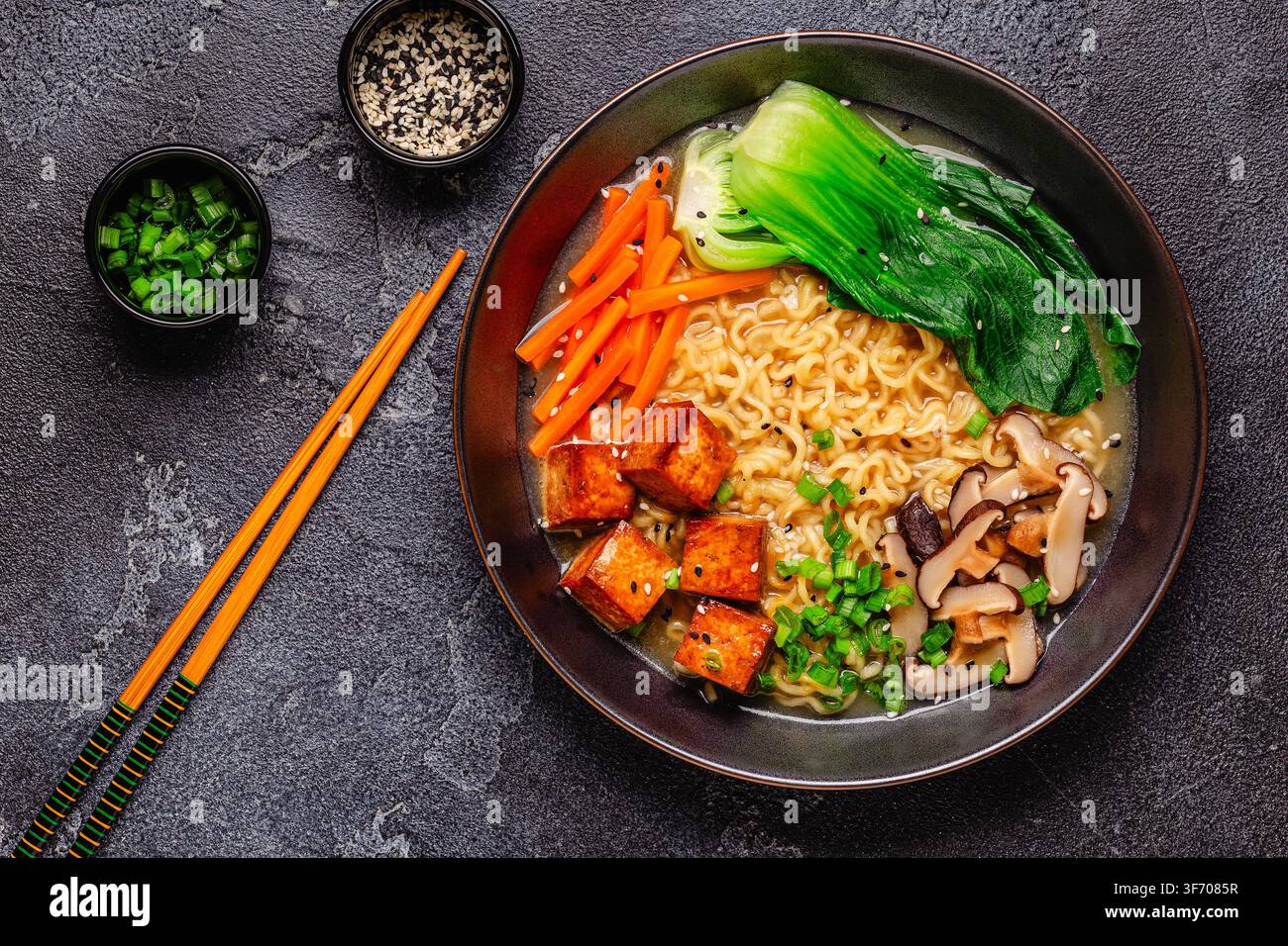Zuppa miso ramen con noodles servita con tofu, bok choy, carote e funghi in una ciotola. Foto Stock