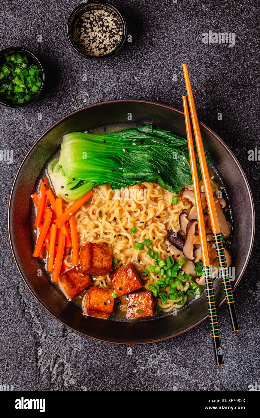 Zuppa miso ramen con noodles servita con tofu, bok choy, carote e funghi in una ciotola. Foto Stock