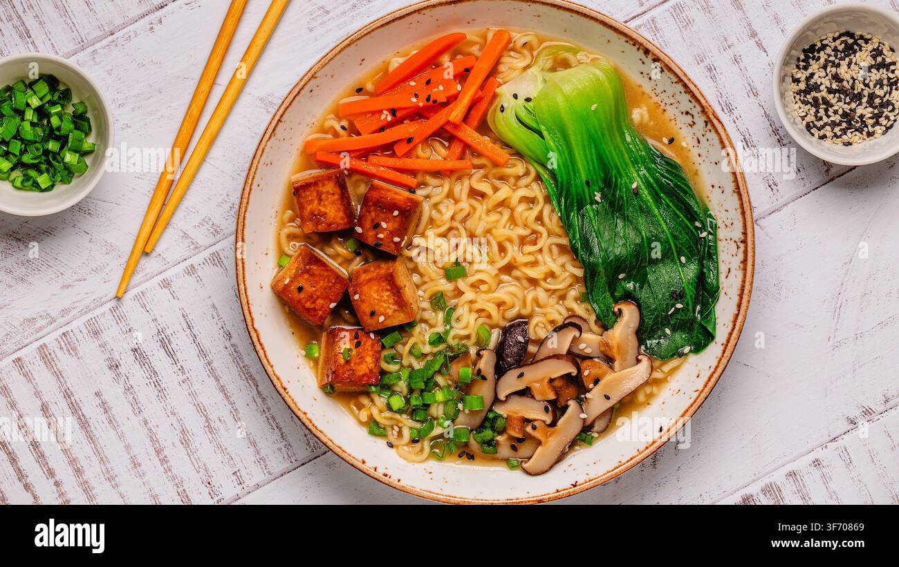 Zuppa miso ramen con noodles servita con tofu, bok choy, carote e funghi in una ciotola. Foto Stock