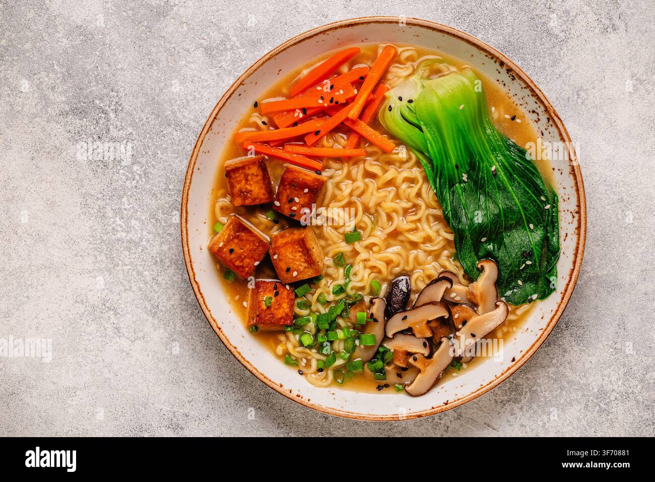 Zuppa miso ramen con noodles servita con tofu, bok choy, carote e funghi in una ciotola. Foto Stock