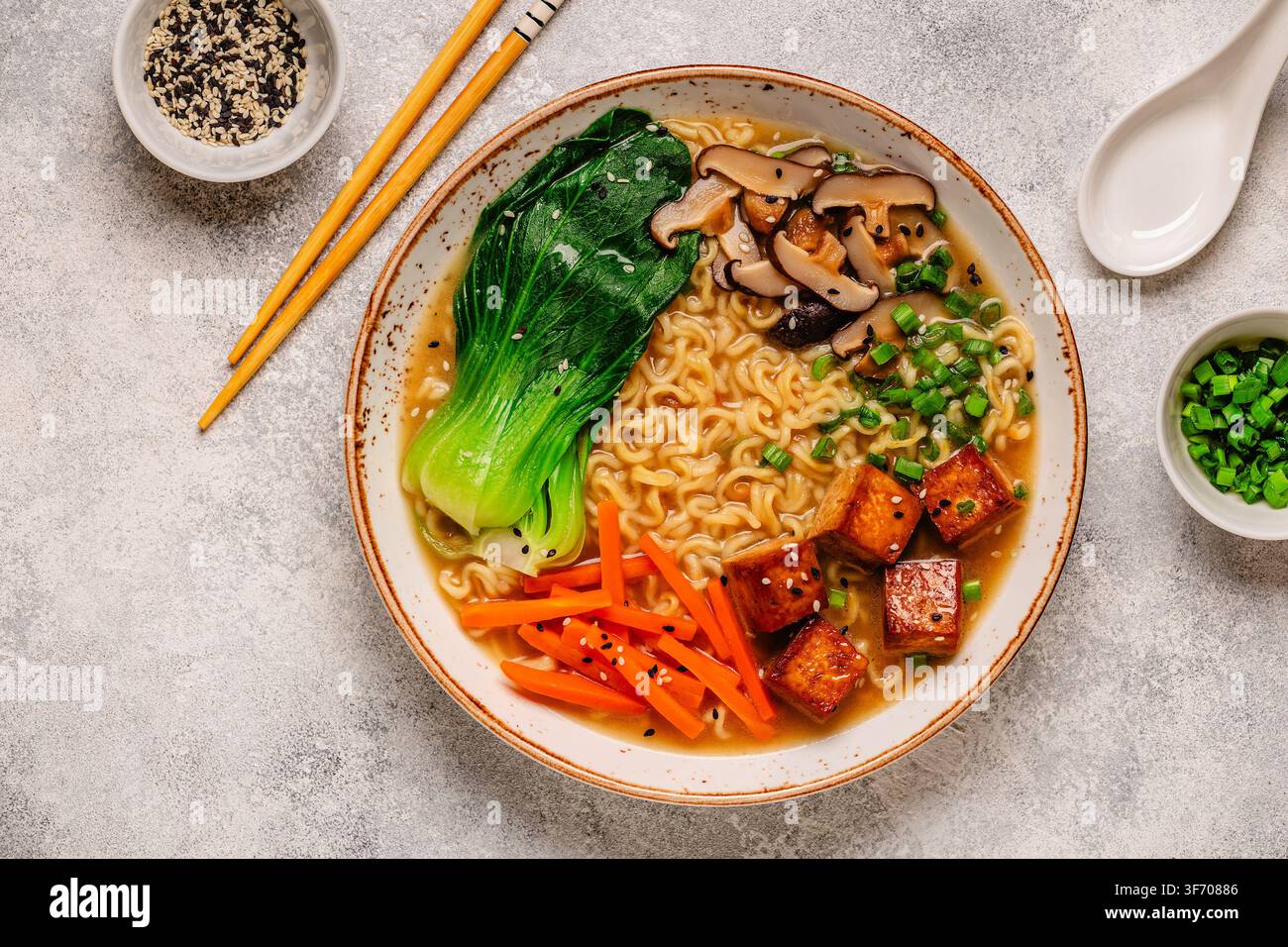 Zuppa miso ramen con noodles servita con tofu, bok choy, carote e funghi in una ciotola. Foto Stock