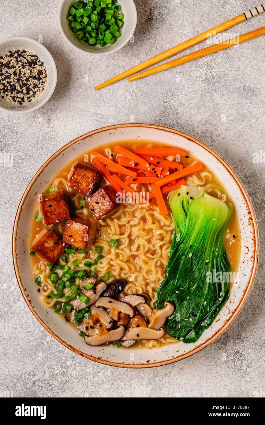 Zuppa miso ramen con noodles servita con tofu, bok choy, carote e funghi in una ciotola. Foto Stock