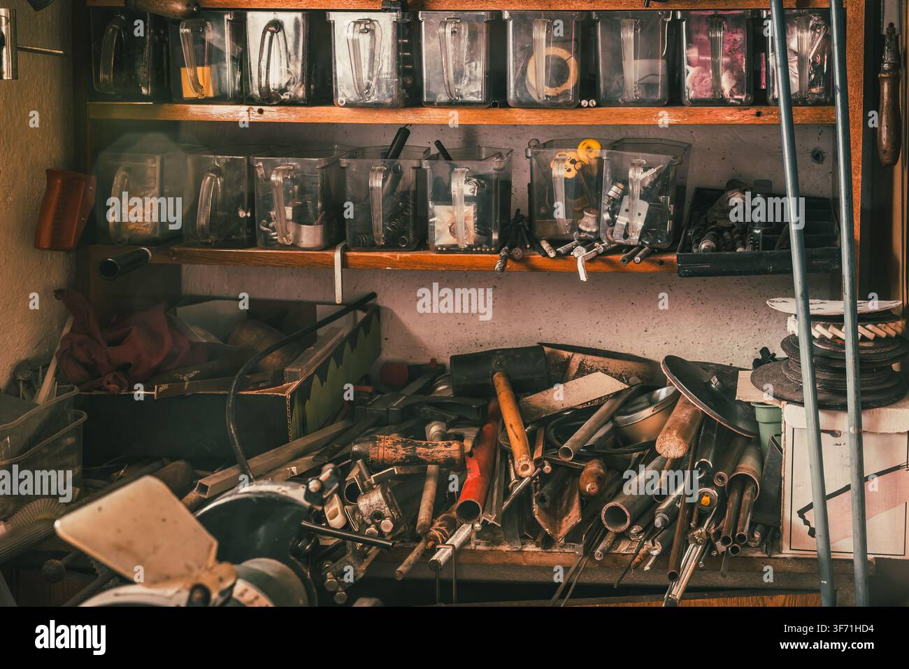 Officina vintage piena di attrezzi e disordine organizzata su scaffali Foto Stock