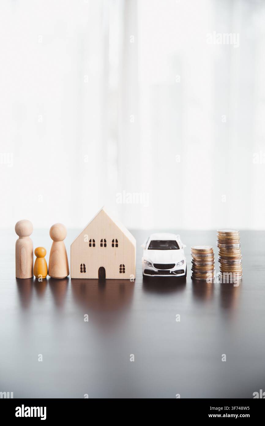 Figure in legno di una famiglia, casa, auto bianca e pile di monete in aumento rappresentano il budgeting domestico, i risparmi familiari, la proprietà abitativa, gli obiettivi del veicolo, finanziario Foto Stock