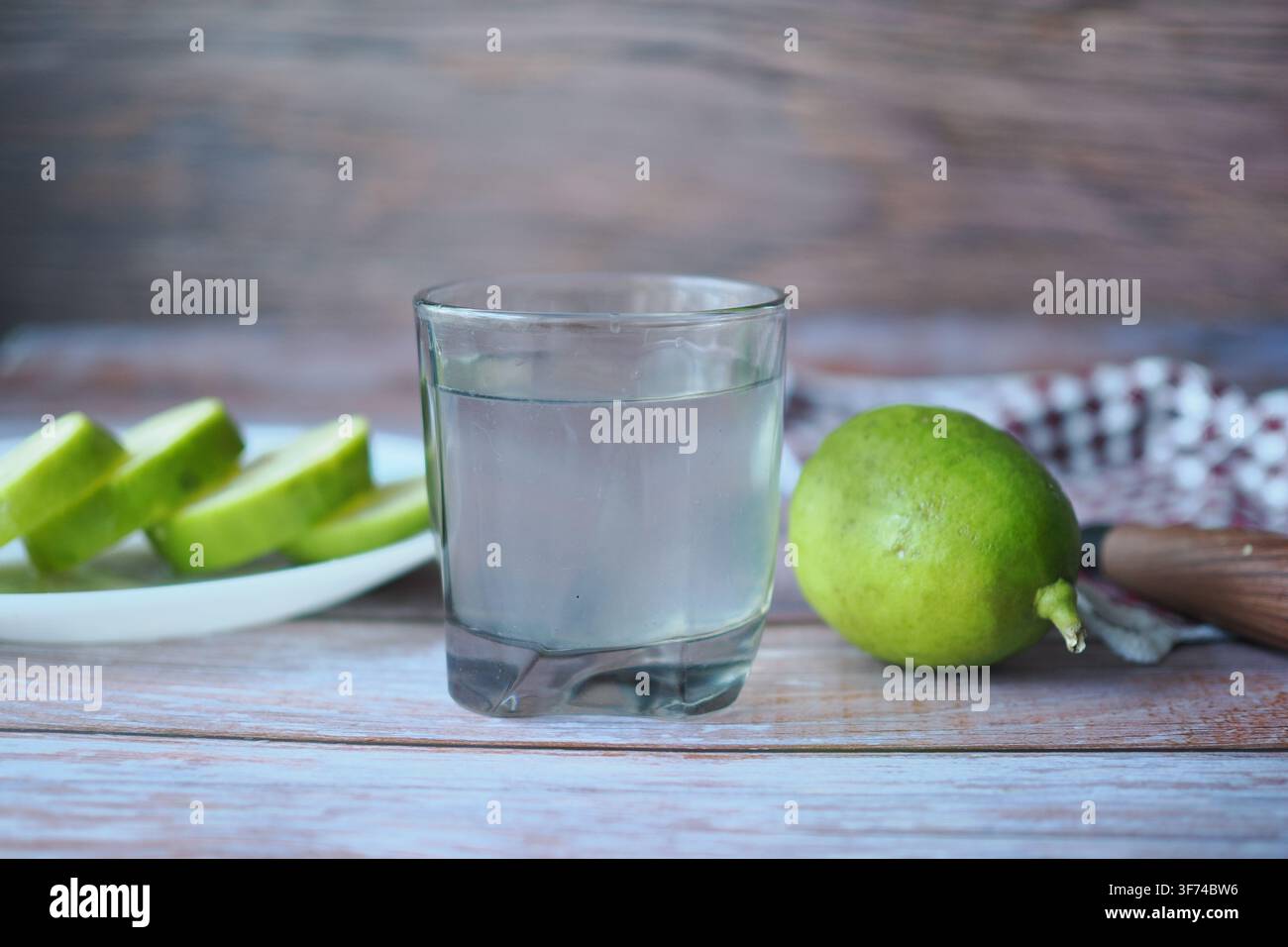 Bevanda fresca al lime con lime tagliati su tavolo di legno Foto Stock