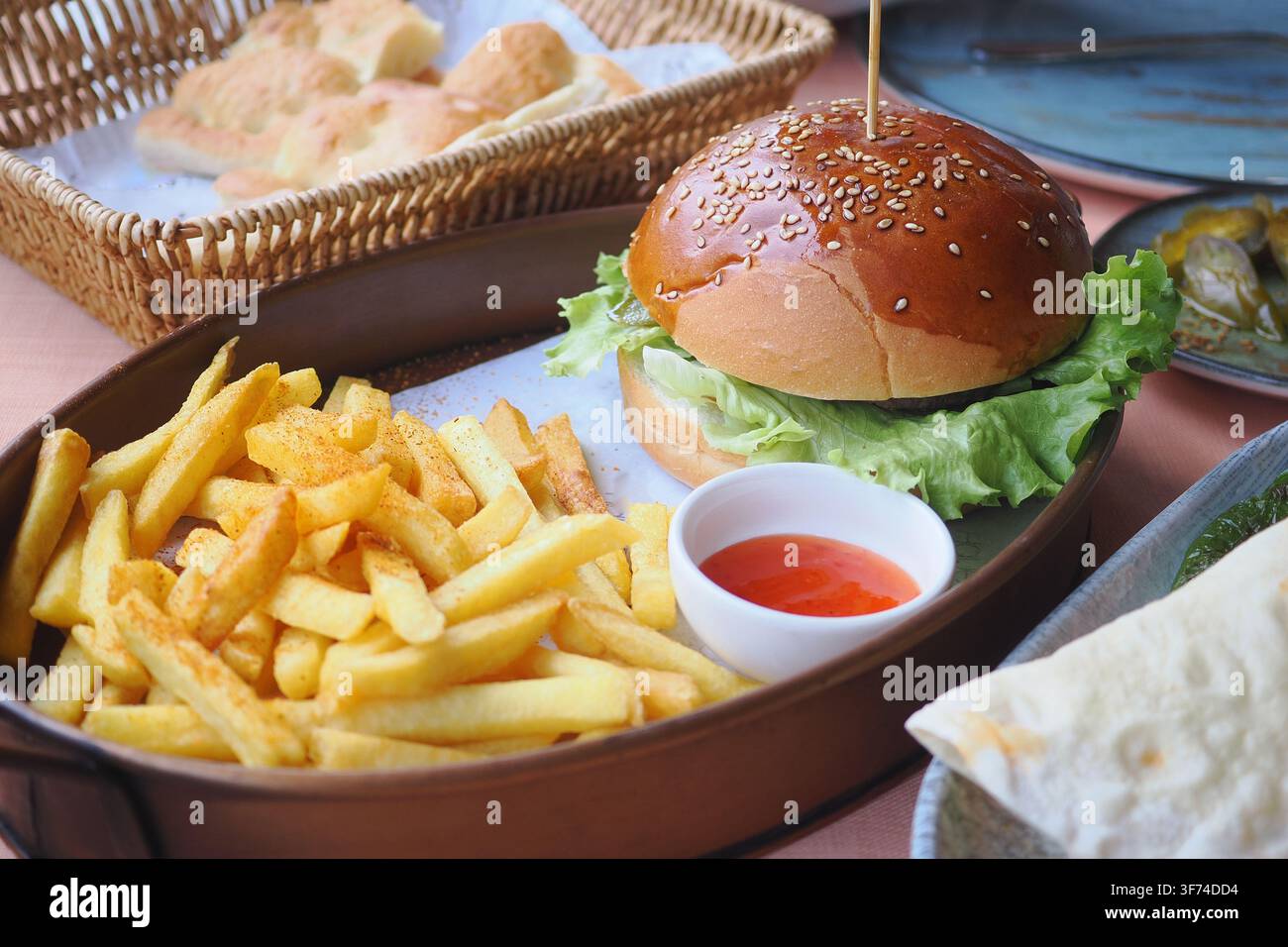 Delizioso hamburger con patatine fritte servito in un ristorante Foto Stock