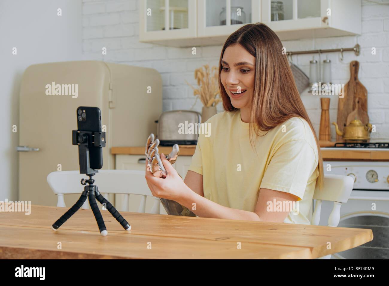 Giovane vlogger donna che registra un video per i social media sulla sua mano bionica, discutendo della tecnologia protesica moderna, dell'inclusione delle persone con disabilità e degli arti artificiali avanzati per i follower online Foto Stock