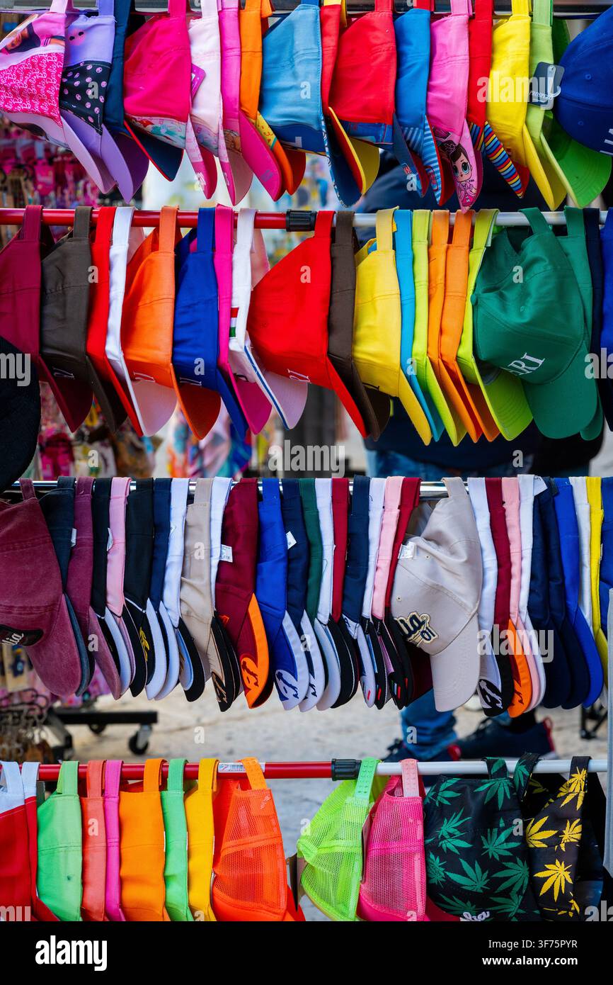Bancarella del mercato con molti cappelli da baseball colorati Foto Stock