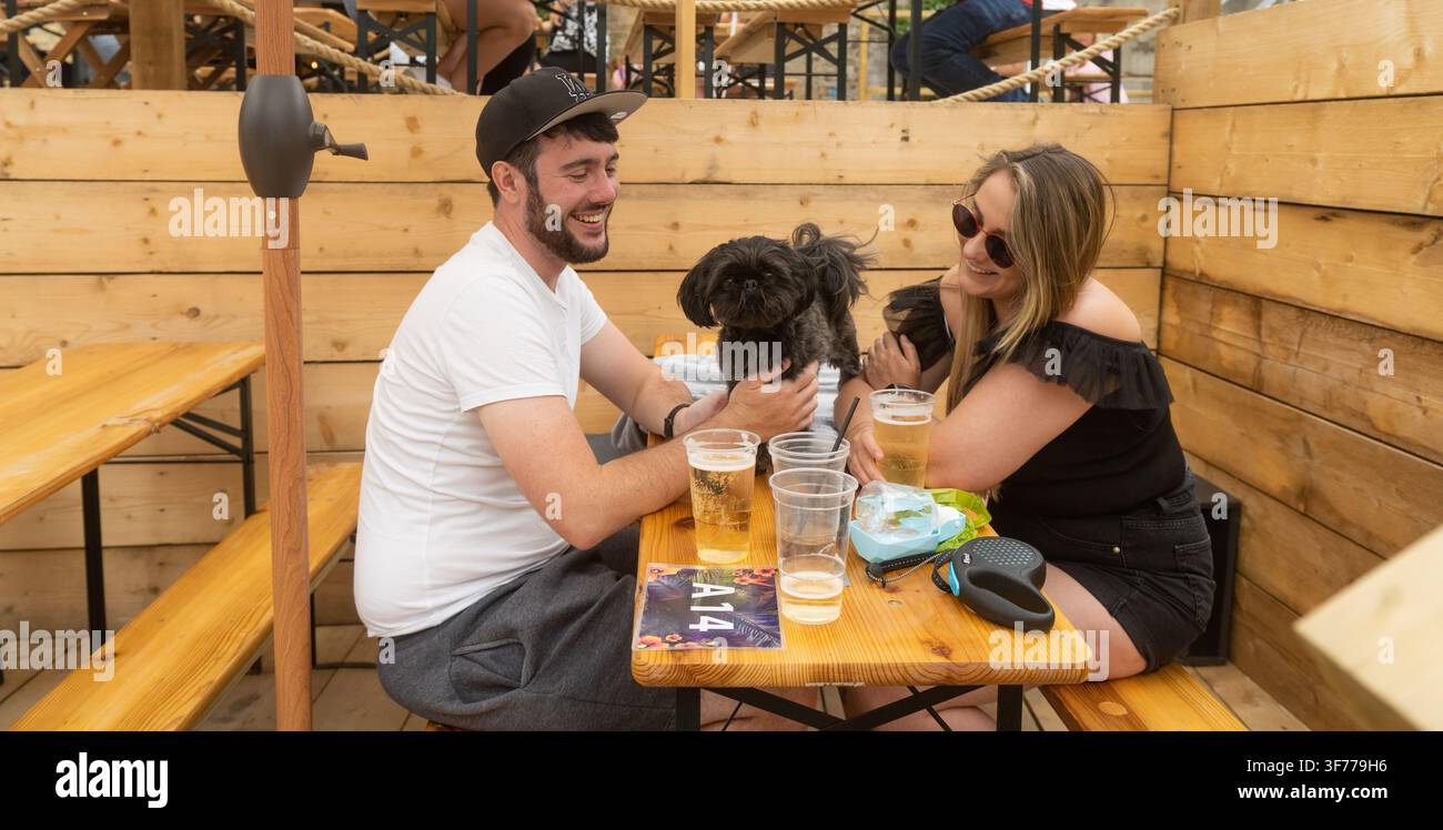 Una coppia si gode bevande e momenti di qualità con il proprio cane al The Garden Bar BR1 a Bromley, Londra. Foto Stock