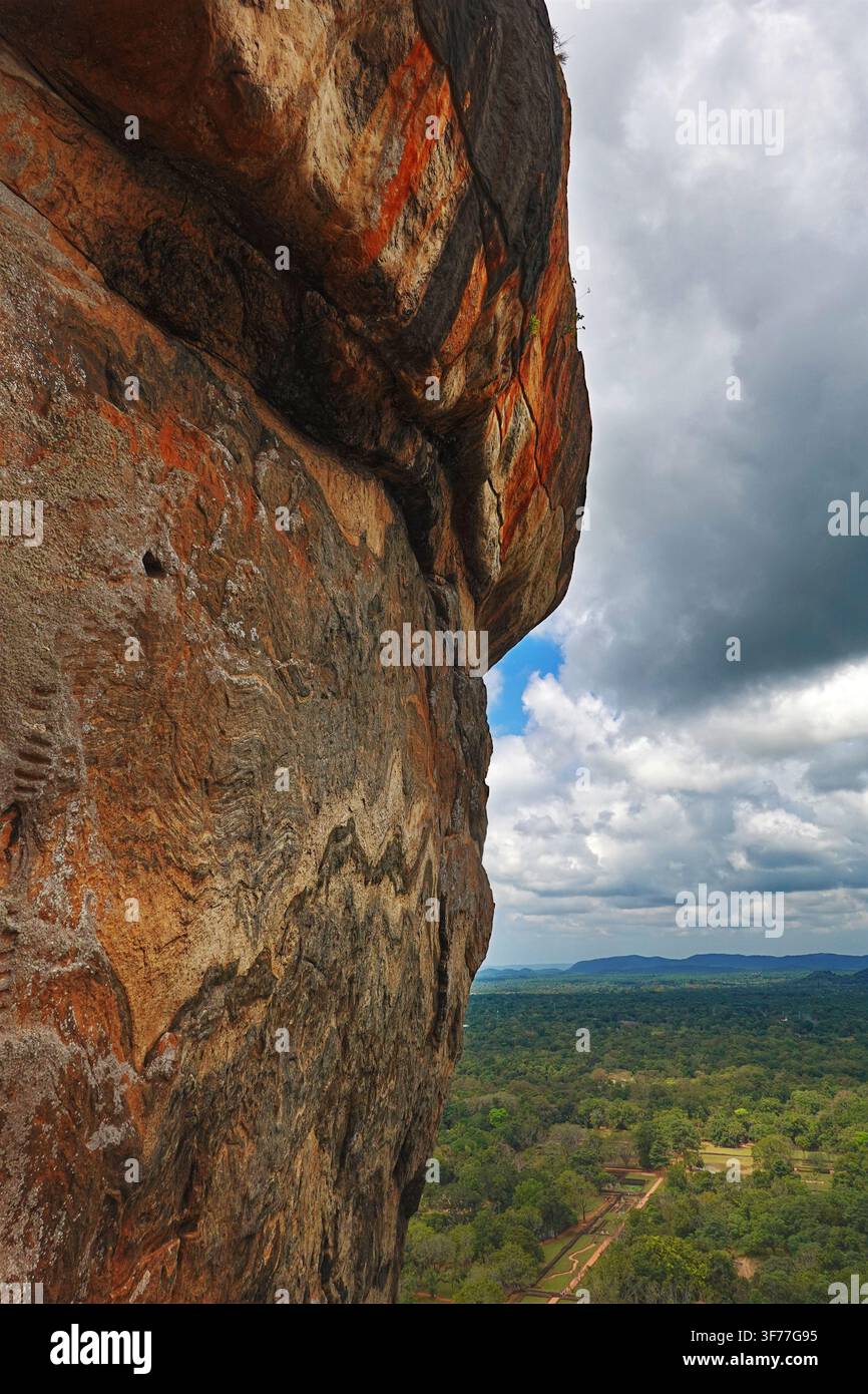 Sigiriya, o la Roccia del Leone, nello Sri Lanka – Guardando attraverso la parete rocciosa ripida dall'alto verso il paesaggio sottostante. Dà un'impressione di altezza Foto Stock