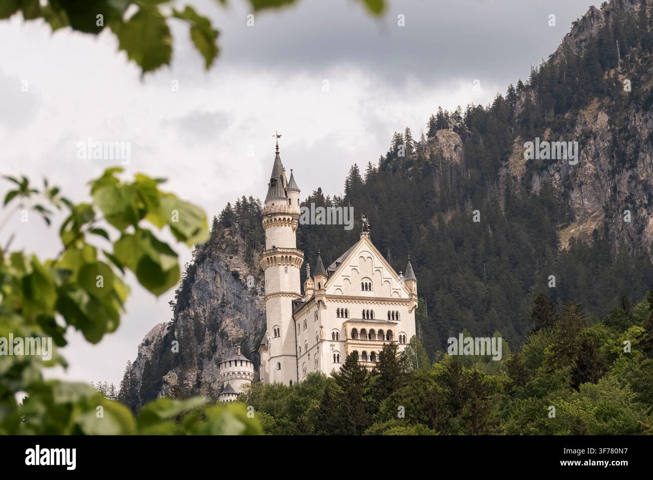 Monarchie silenziose che si ergono dai pendii montuosi nebbiosi sotto un cielo minaccioso (Schwangau, Germania: 10-mai-2026) Foto Stock