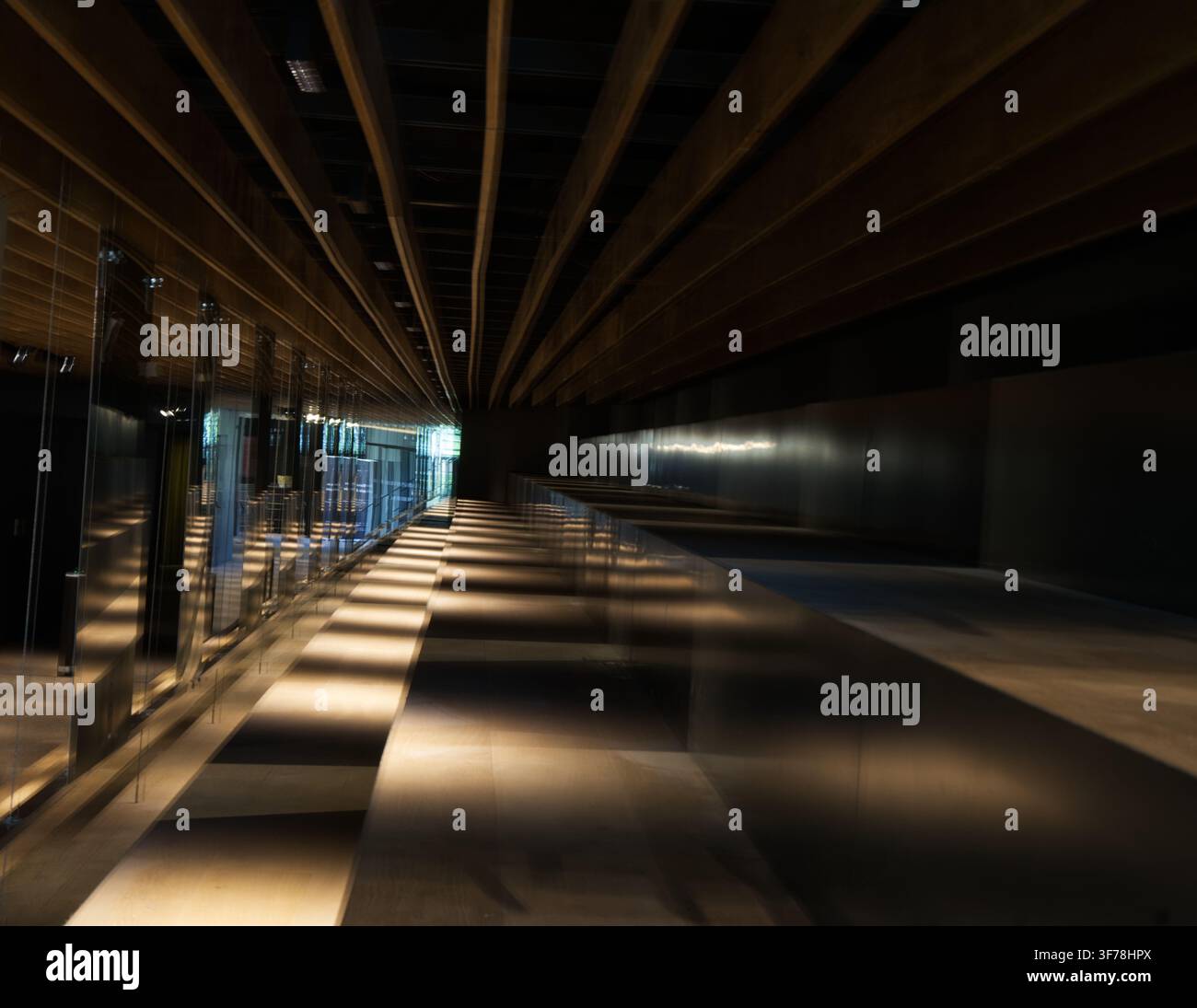 Interazione drammatica di luce e ombra proiettata da un soffitto a doghe Foto Stock