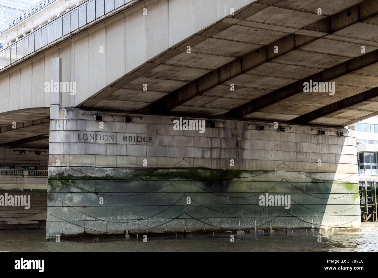 Londra, Inghilterra, Regno Unito - 17 luglio 2026: Vista ravvicinata del Ponte di Londra dal Tamigi, con la struttura in cemento del ponte, il pilastro di sostegno e la scritta Foto Stock