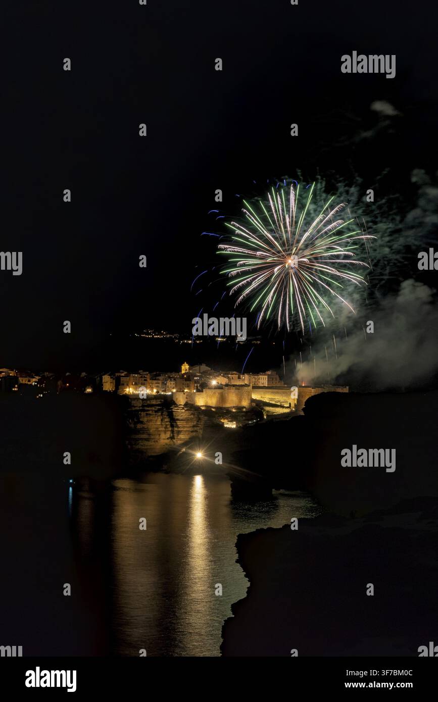 Fuochi d'artificio che esplodono nel cielo notturno sopra Bonifacio, Francia, riflettendosi sul Mar Mediterraneo, Bonifacio, Corsica, Francia Foto Stock