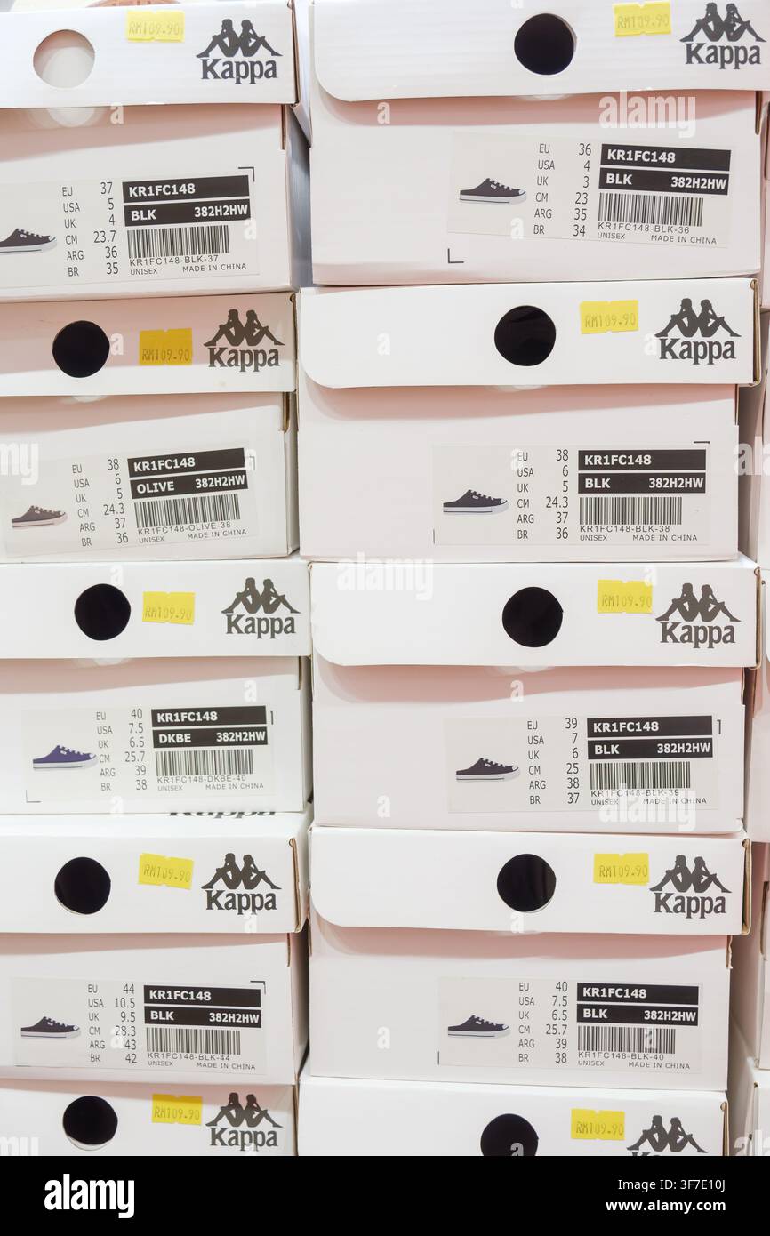Penang, Malesia – 27 novembre 2025: Un negozio al dettaglio espone più scatole impilate di scarpe Kappa in vari colori e stili, presentando il prodotto i Foto Stock