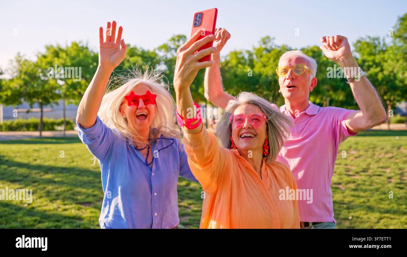 Amici anziani si divertono a scattare un selfie di gruppo nel parco Foto Stock