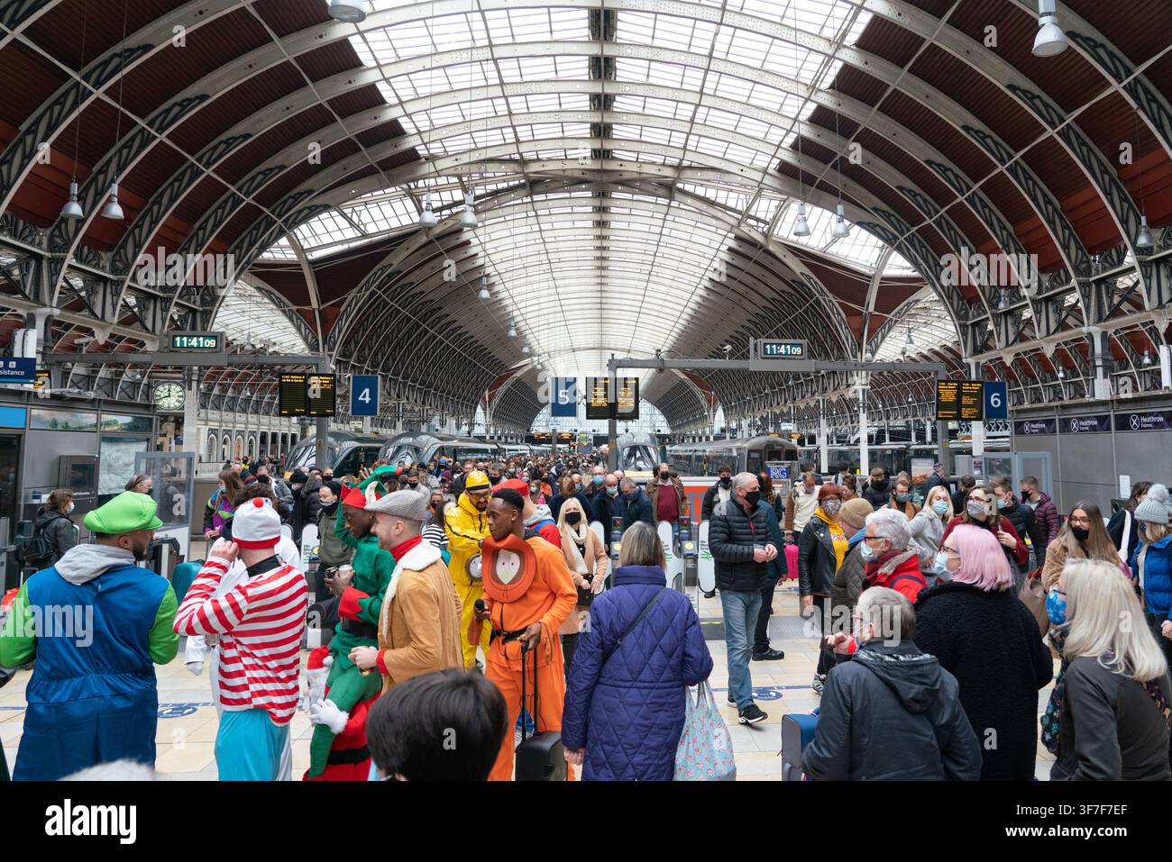 Un gruppo in costume, tra cui Kenny e Waldo, si raduna alla storica stazione di Paddington a Londra per un evento di beneficenza festivo. Foto Stock
