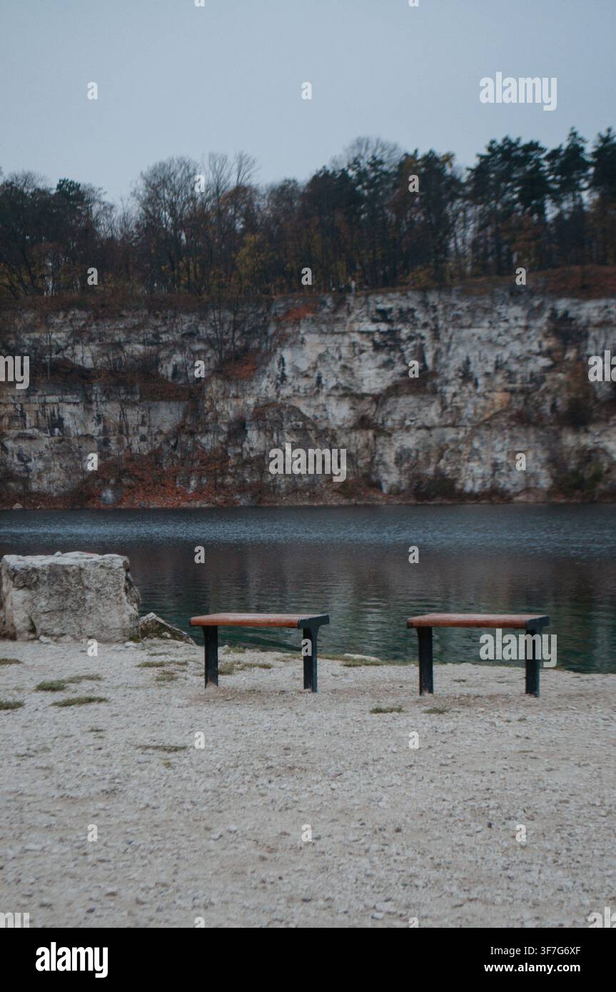 Due panchine che si affacciano su un tranquillo lago Foto Stock
