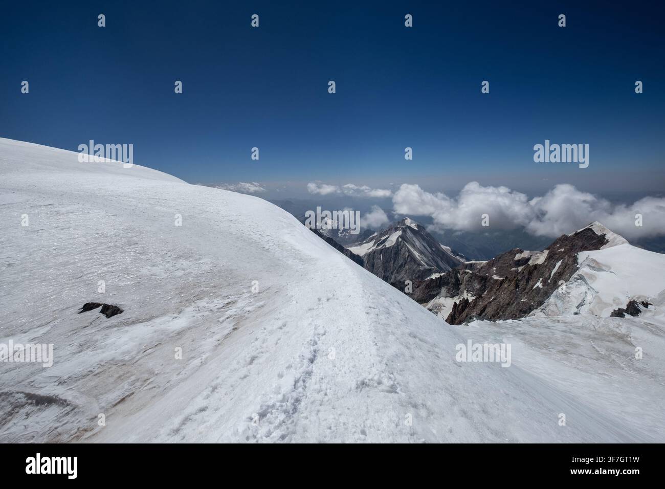 Cresta alpina innevata sul Massiccio del Monte Bianco Vista panoramica sulle montagne Alpi francesi Chamonix Vette Nuvole Cielo blu profondo Alta quota Avventura all'aperto Estrema Foto Stock