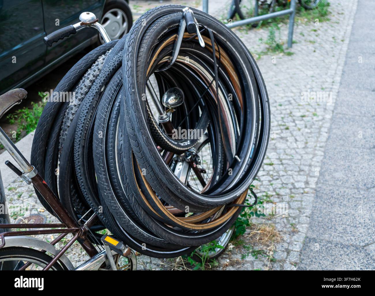 Primo piano di numerosi pneumatici da bicicletta usati ammucchiati intorno a una bicicletta, Germania. Un grande mucchio di pneumatici da bicicletta usati è trasportato su una bicicletta. Foto Stock