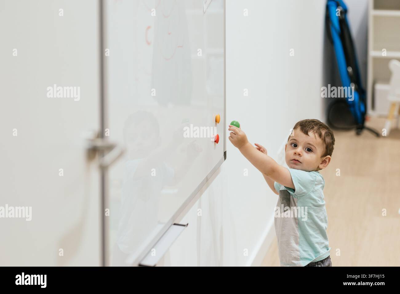 Bambino che gioca con magneti su una lavagna bianca nell'ufficio dell'ottico Foto Stock