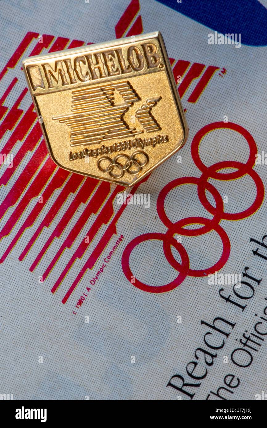 Primo piano di una spilla da bavero in oro 14 carati con logo della birra Michelob, sponsor ufficiale dei Giochi Olimpici estivi del 1984 a Los Angeles, Stati Uniti Foto Stock