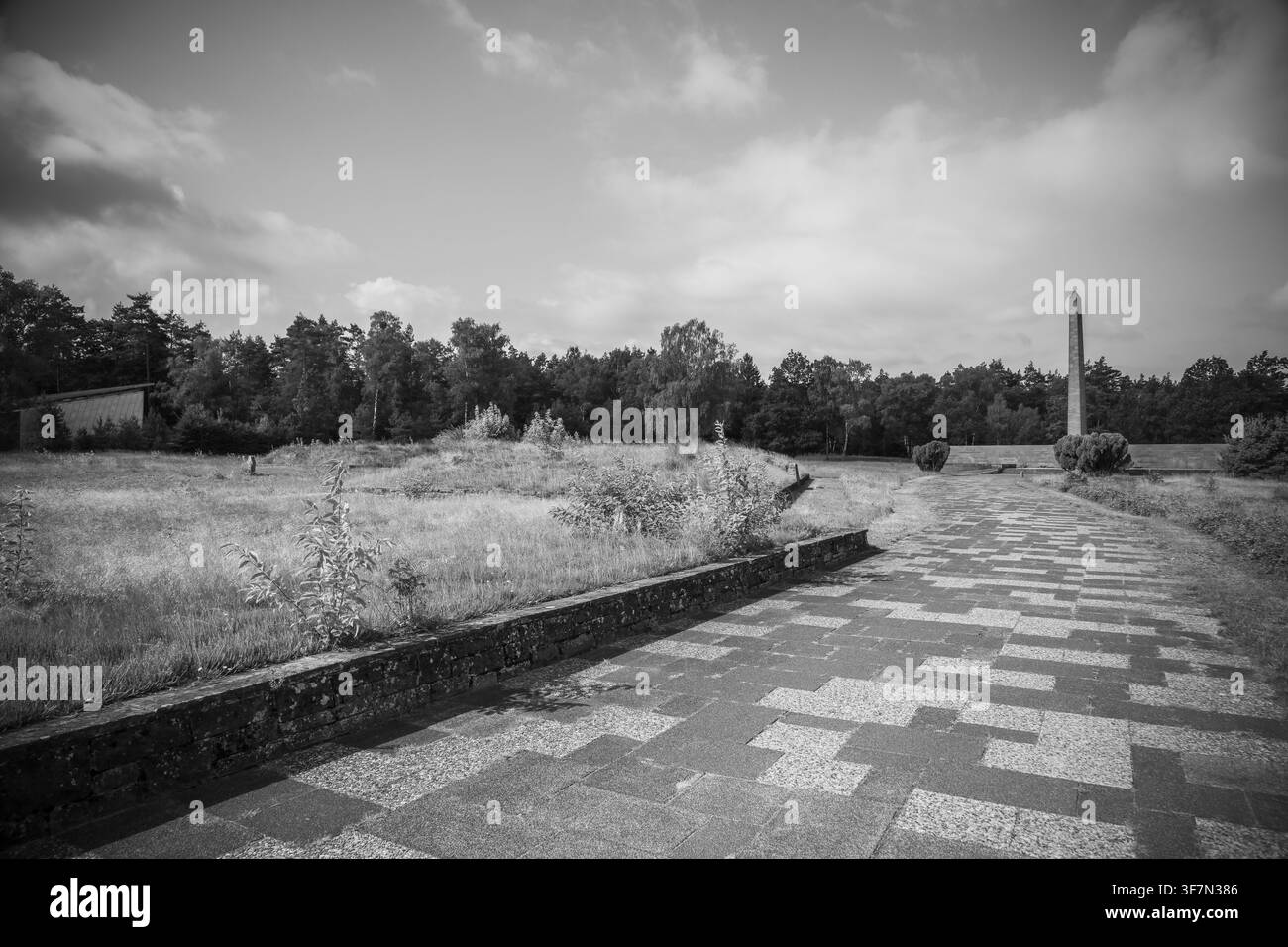 Cimitero nel sito storico del campo con obelisco e muro di iscrizioni, fosse comuni, Casa del Silenzio a sinistra, ex campo di concentramento nazista Foto Stock