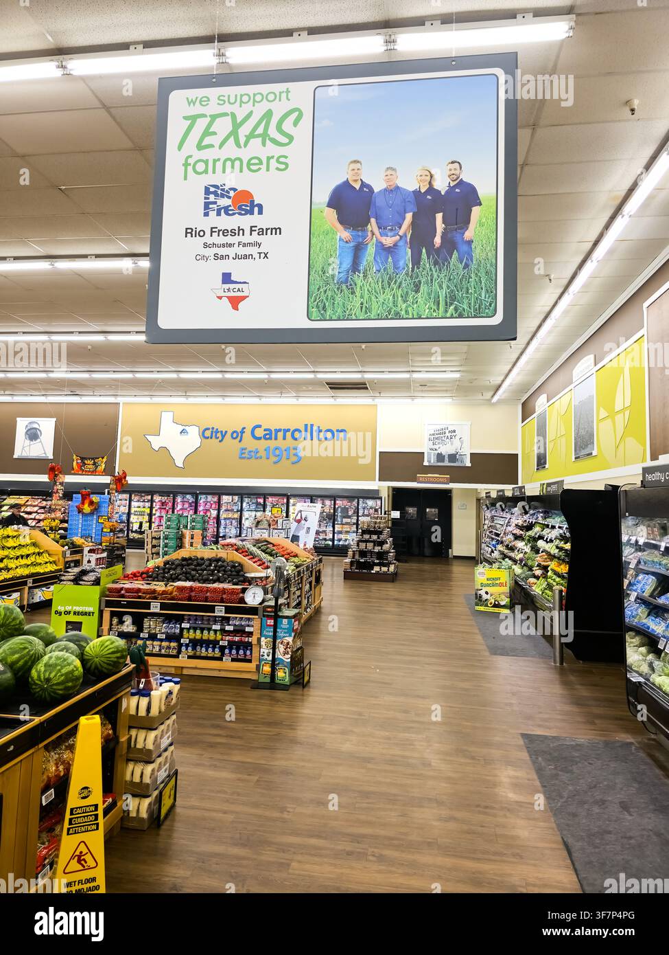 ADDISSON, TX, USA - 21 LUGLIO 2026: Vista interna di un negozio di alimentari che mostra esposizioni di prodotti freschi e un cartello ben visibile a sostegno degli agricoltori del Texas an Foto Stock