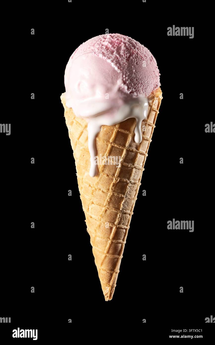 Cucchiaio di gelato alla fragola rosa in cono di waffle che si scioglie isolato su sfondo nero, verticale Foto Stock