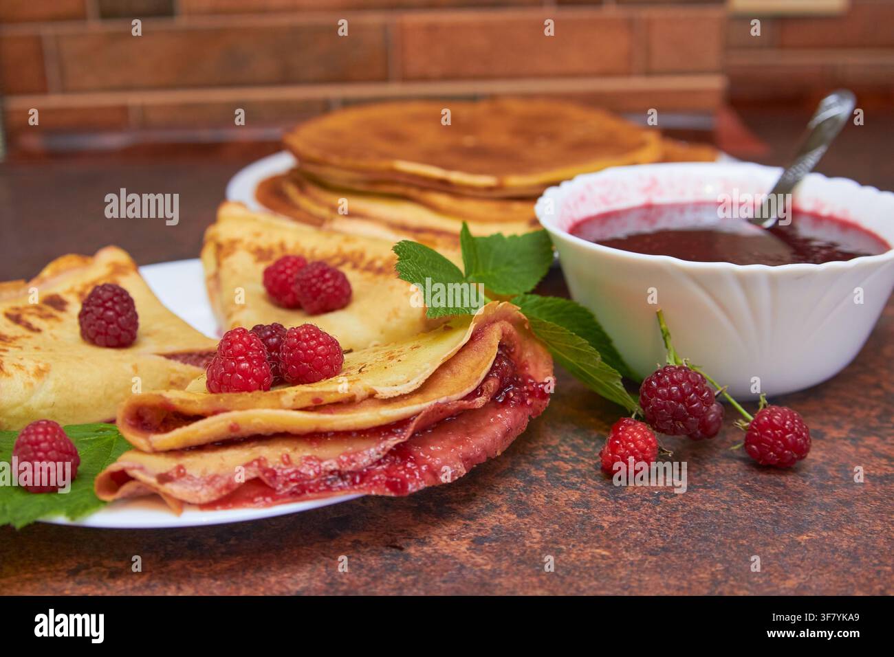 pancake appetitosi con lamponi in cucina Foto Stock