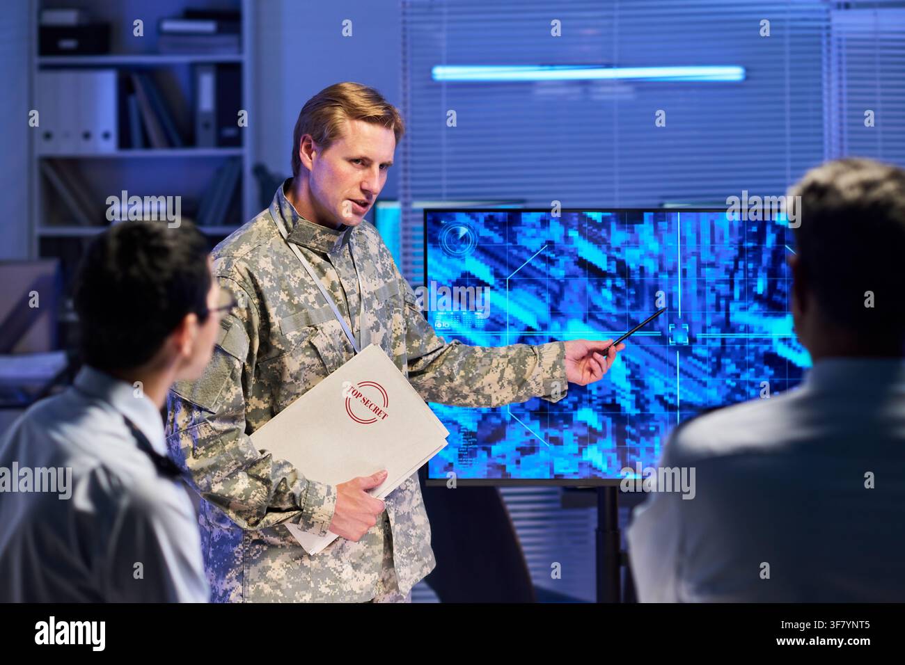 Ufficiale militare che tiene una presentazione ai colleghi nella sala di controllo Foto Stock