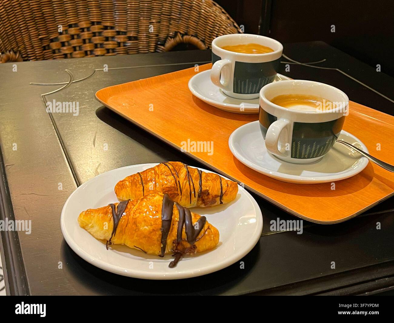 Due tazze di caffè con due minicroissant in una caffetteria. Foto Stock